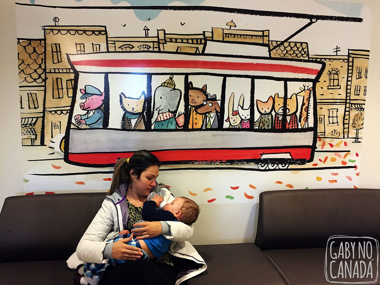 Thomas e sua amada mamadeira no colo da mamãe enquanto esperamos para sermos atendidos em uma clínica.