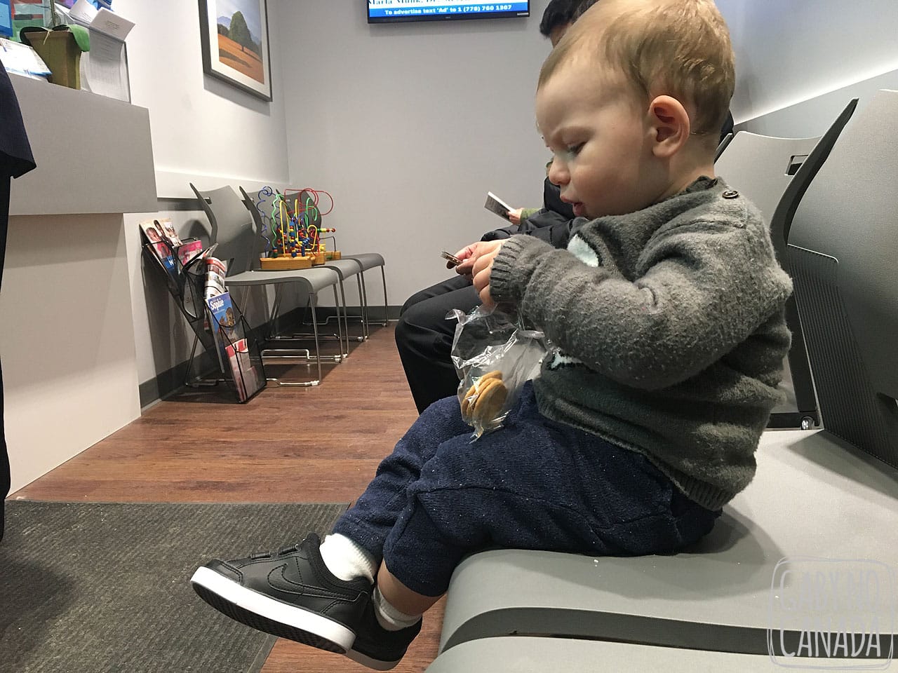 Thomas lendo um livrinho enquanto espera para ser atendido em uma clínica.